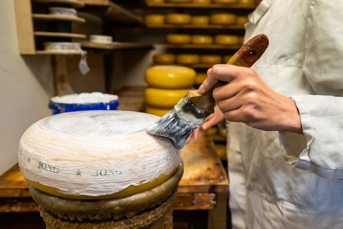 close up van een hand die een kaas coat